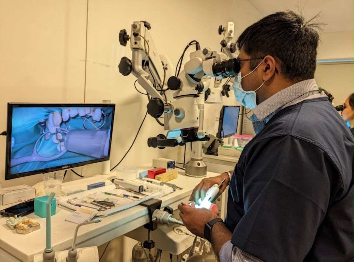 Dr. Amit Malik treating a patient at the dental operating microscope
