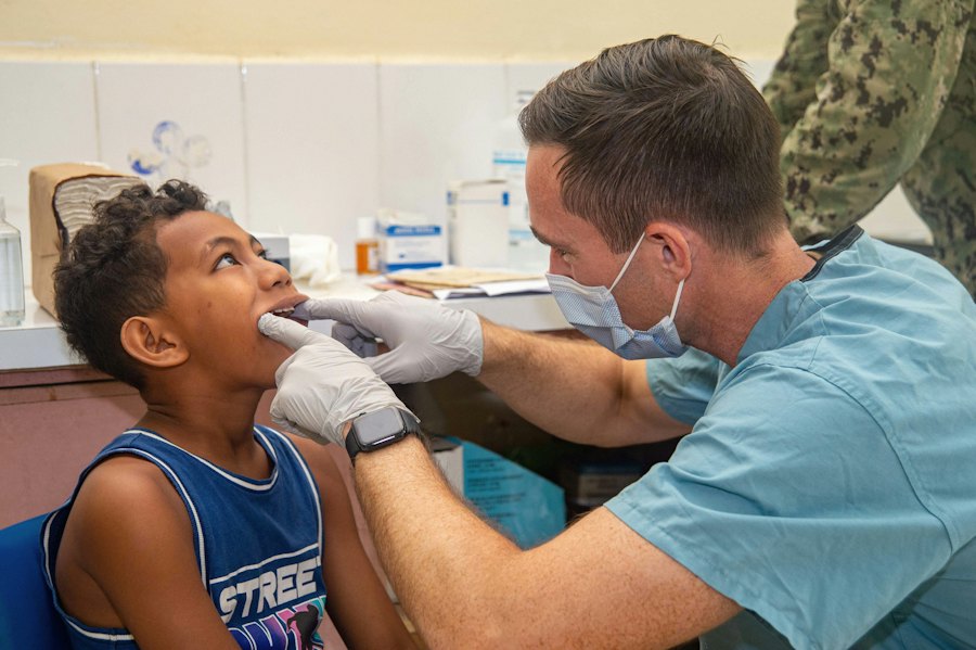 A dentist examining a young boy's teeth