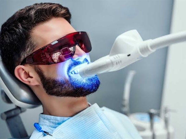 A patient having a whitening light applied at the clinic